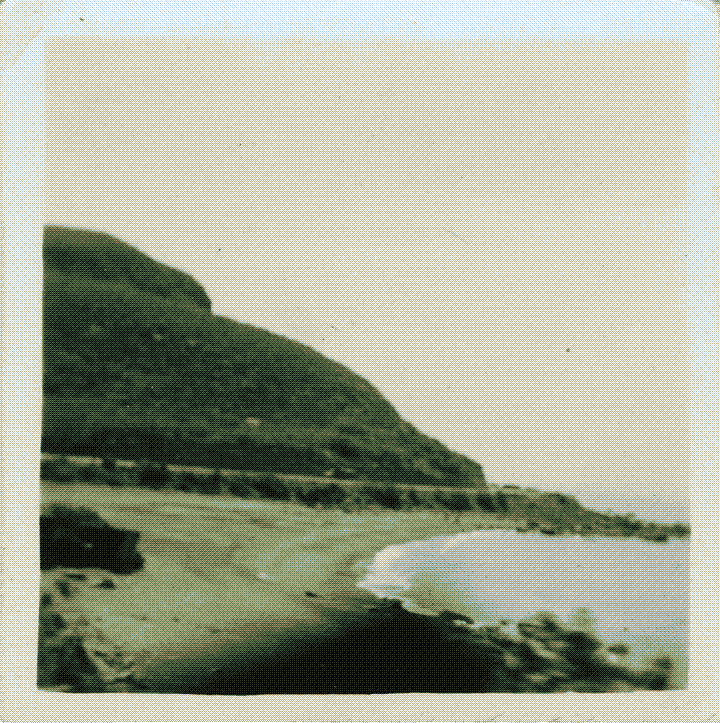 A beach with a hill in the background